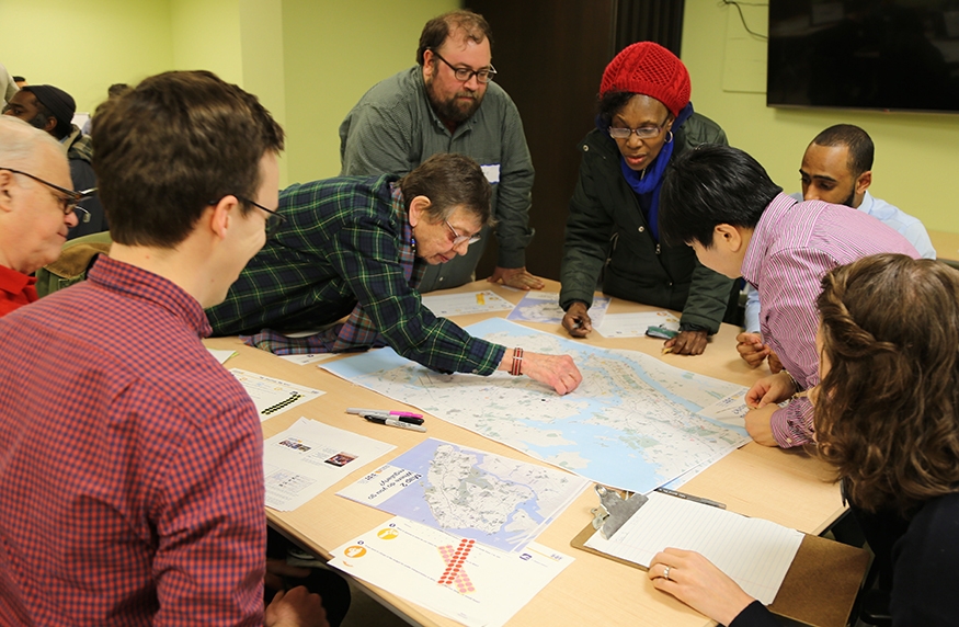 People gathered around a large map at a meeting