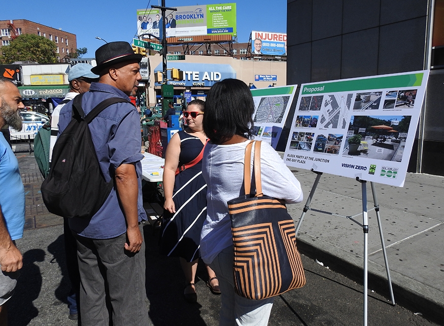 People looking at plans for a DOT street redesign at a one day plaza